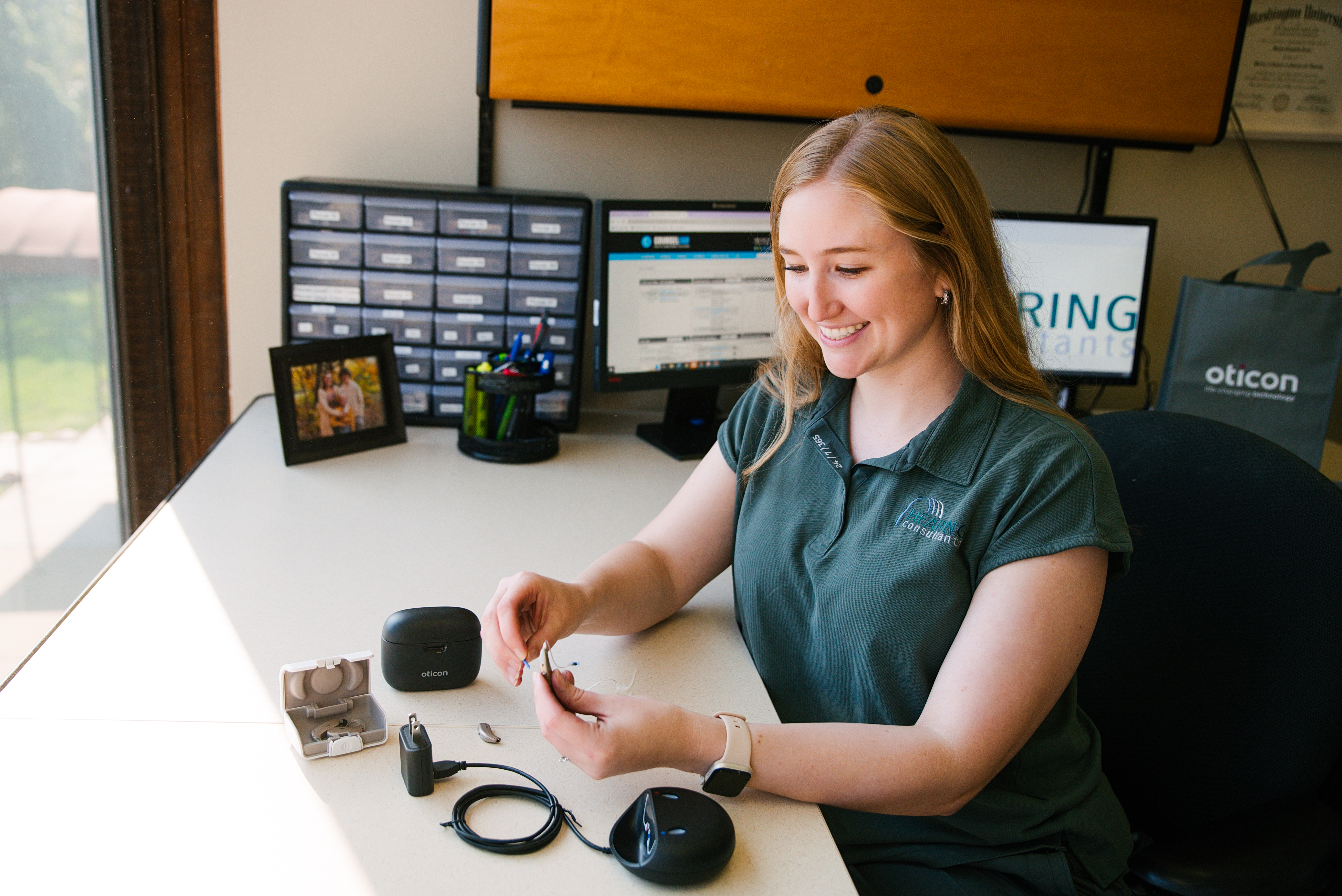 The staff at Hearing Consultants setting up a hearing aid