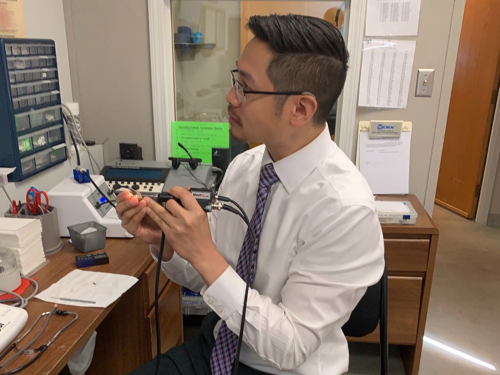 Alex Lee working on a hearing aid