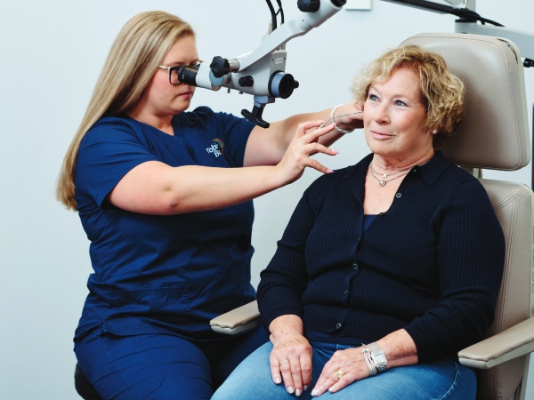 Audiologist checking patient ear