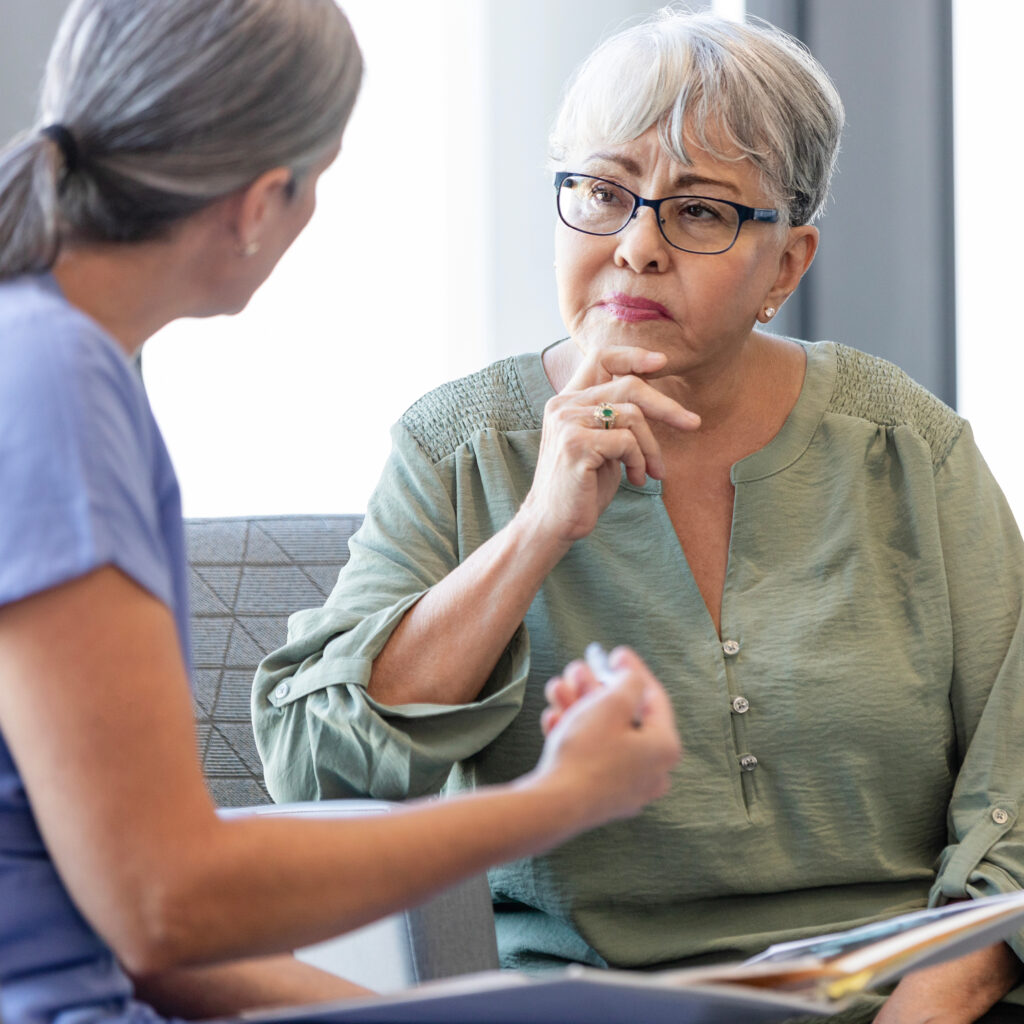 Concerned woman speaking with a hearing care provider, representing a hearing evaluation or audiology consultation.