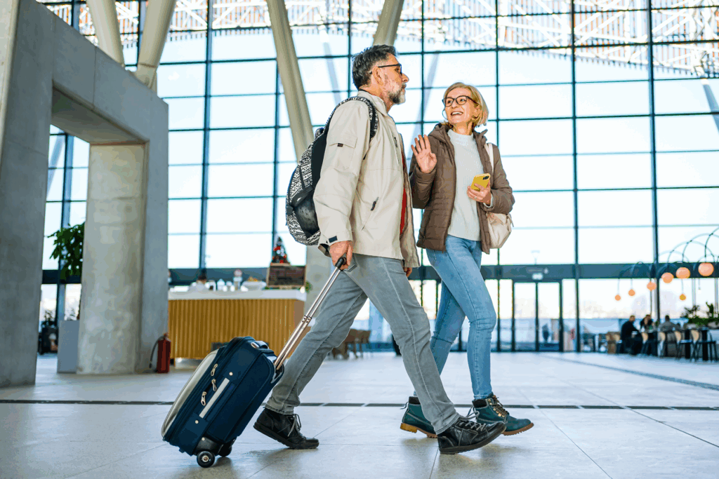Travelers walk through a bright airport terminal - one of the public spaces where Auracast can stream announcements directly to compatible hearing aids.