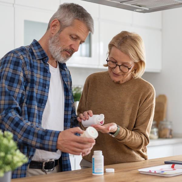 Couple standing in their kitchen reading medication labels together, highlighting awareness of how certain medications can affect hearing health.