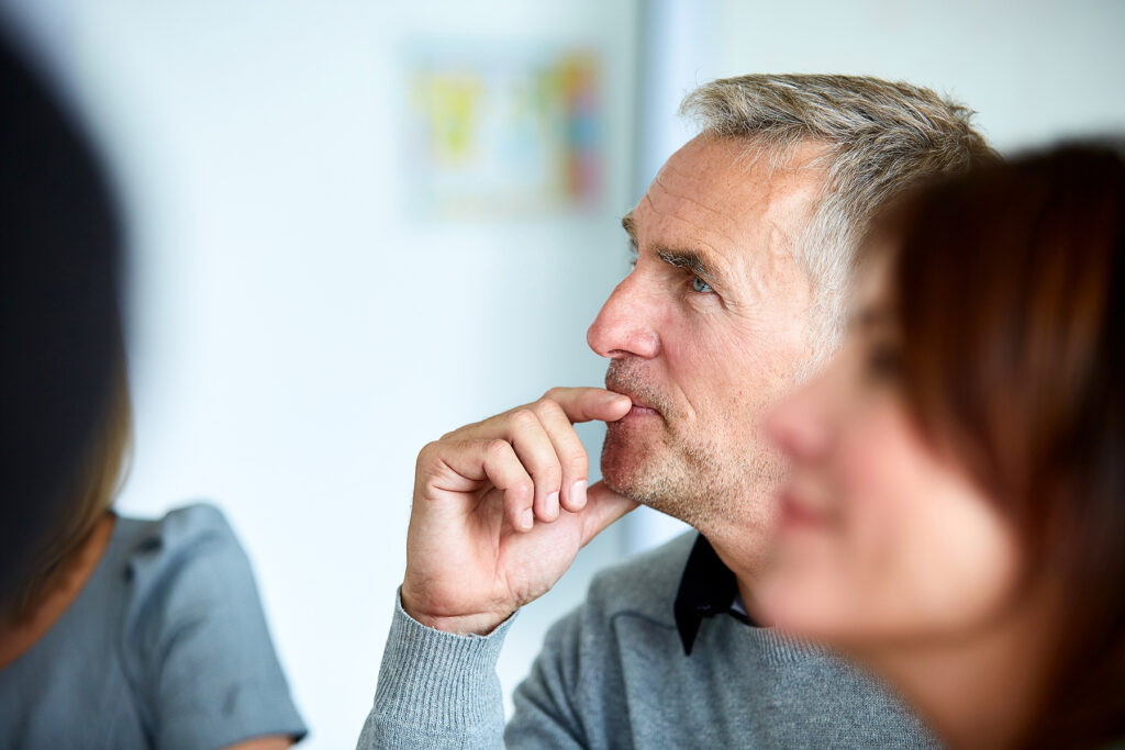 Man attentively listening during a conversation, symbolizing how hearing care helps restore focus and confidence.