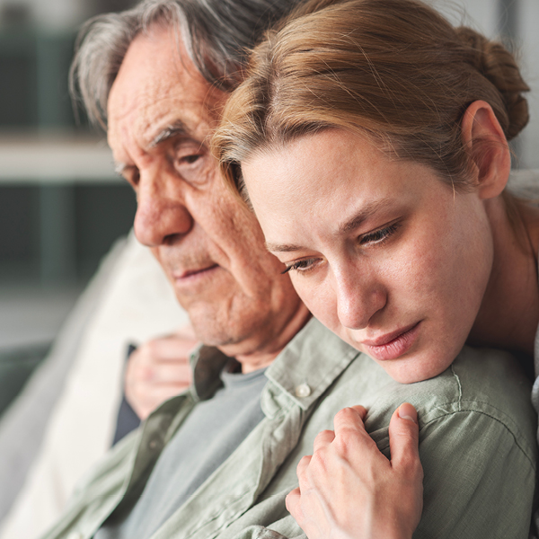 Caregiver supporting an aging adult experiencing hearing loss, highlighting the emotional and cognitive impact linked to dementia risk.