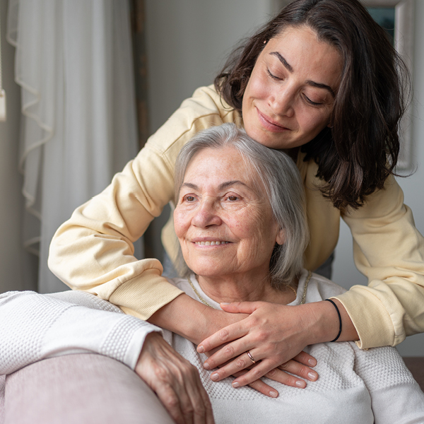 Adult daughter hugging her mother at home showing connection and confidence made easier with better hearing