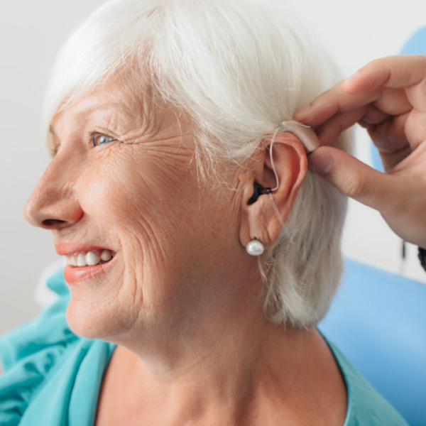 Close-up of hearing aid being fitted on older adult to support hearing and cognitive health