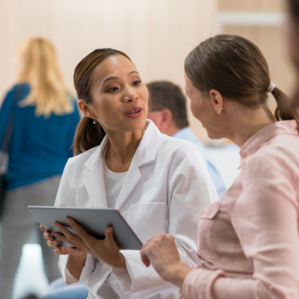 Hearing care professional speaking with a patient, illustrating access to care and personalized hearing evaluation