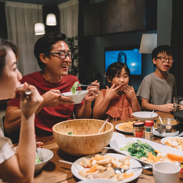 Family enjoying dinner together, showing the importance of clear hearing in conversations and social connection