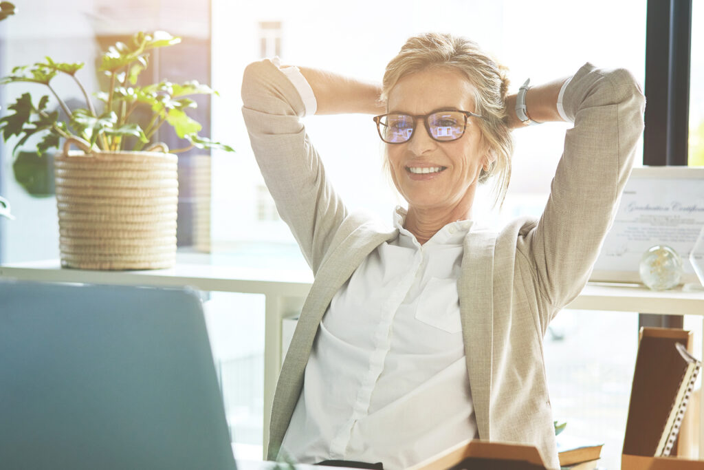 Woman relaxing at her desk after using a laptop, representing relief from tinnitus through modern sound therapy and treatment technologies.