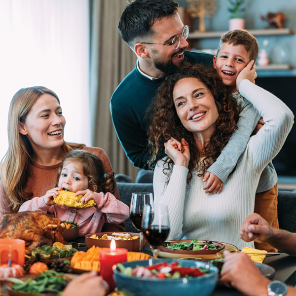 Happy family gathered around a holiday dinner table, showing the importance of staying connected through hearing loss communication strategies