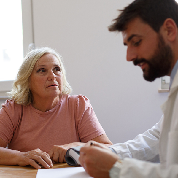 Older woman with hearing concerns listening attentively during a consultation with her hearing specialist