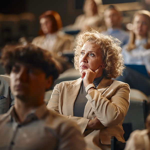 Woman with hearing loss concentrating during a live performance, highlighting difficulty hearing in crowded concert venues
