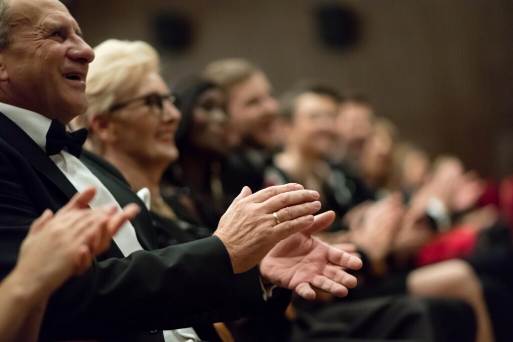 Audience enjoying a live concert with clear sound, representing improved hearing access with assistive listening technology like Auracast