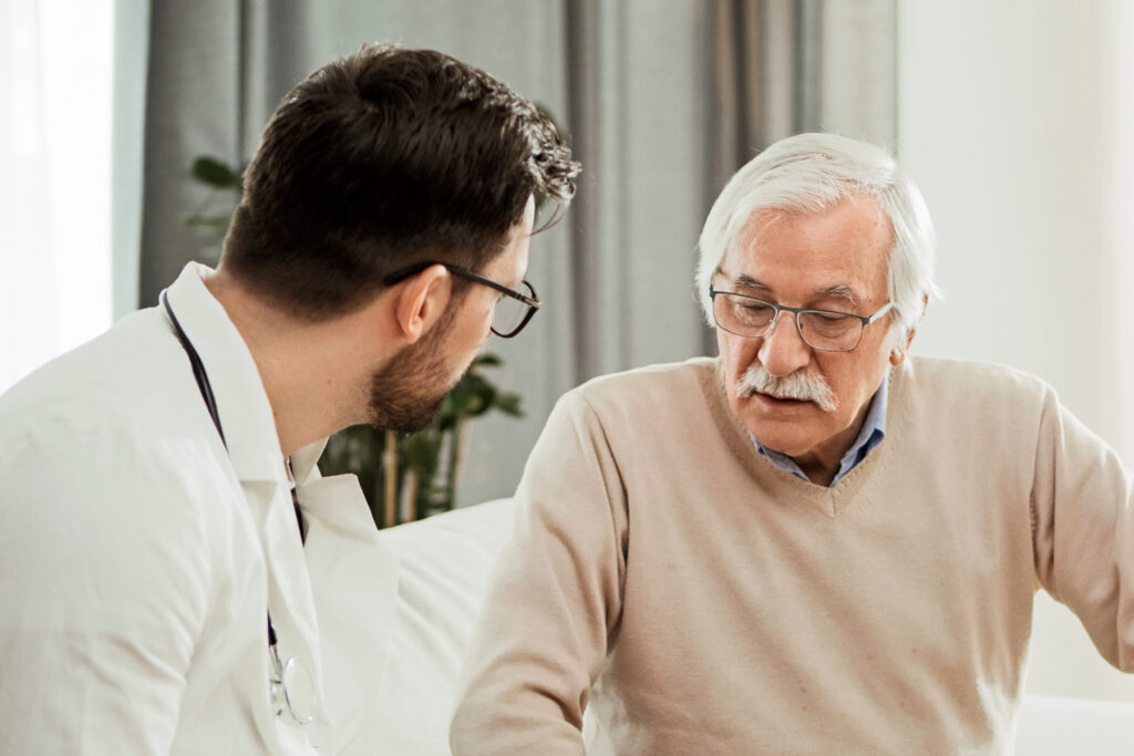 Hearing care provider reviewing hearing test results with an older man during a comprehensive hearing evaluation